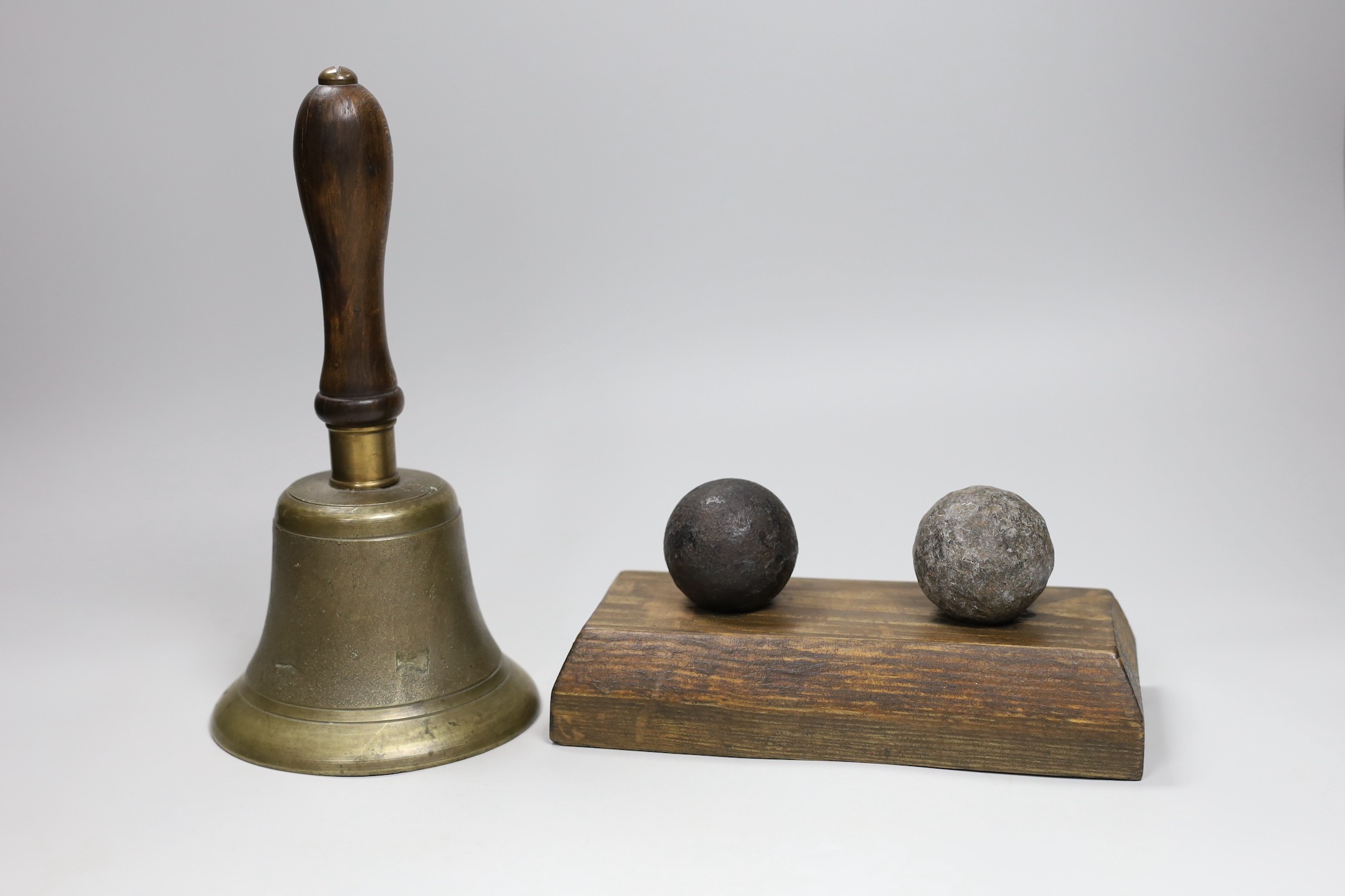 Two canon balls, a brass hand bell marked A.R.P. and a Chinese sword